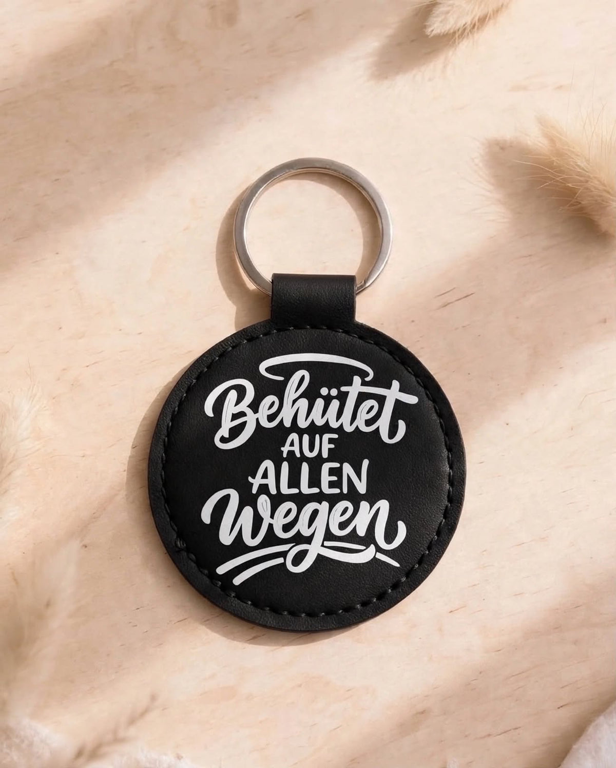 Schlüsselanhänger Behütet auf allen Wegen schwarz - runder Kunstleder Anhänger mit weissem Spruch auf Holztisch - Geschenk Schutzengel Glücksbringer für Autofahrer