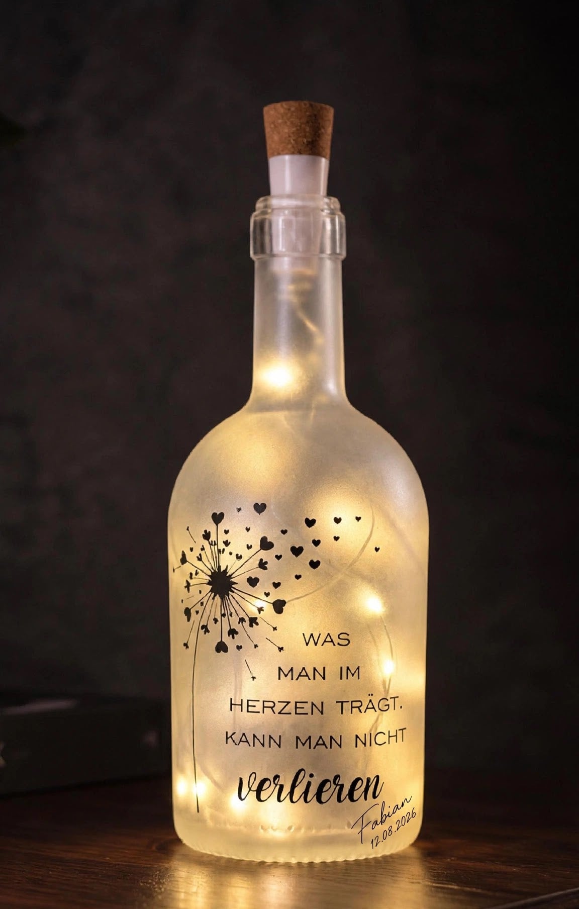 Leuchtendes Gedenklicht LED Flaschenlicht Pusteblume Was man im Herzen trägt vor dunklem Hintergrund
