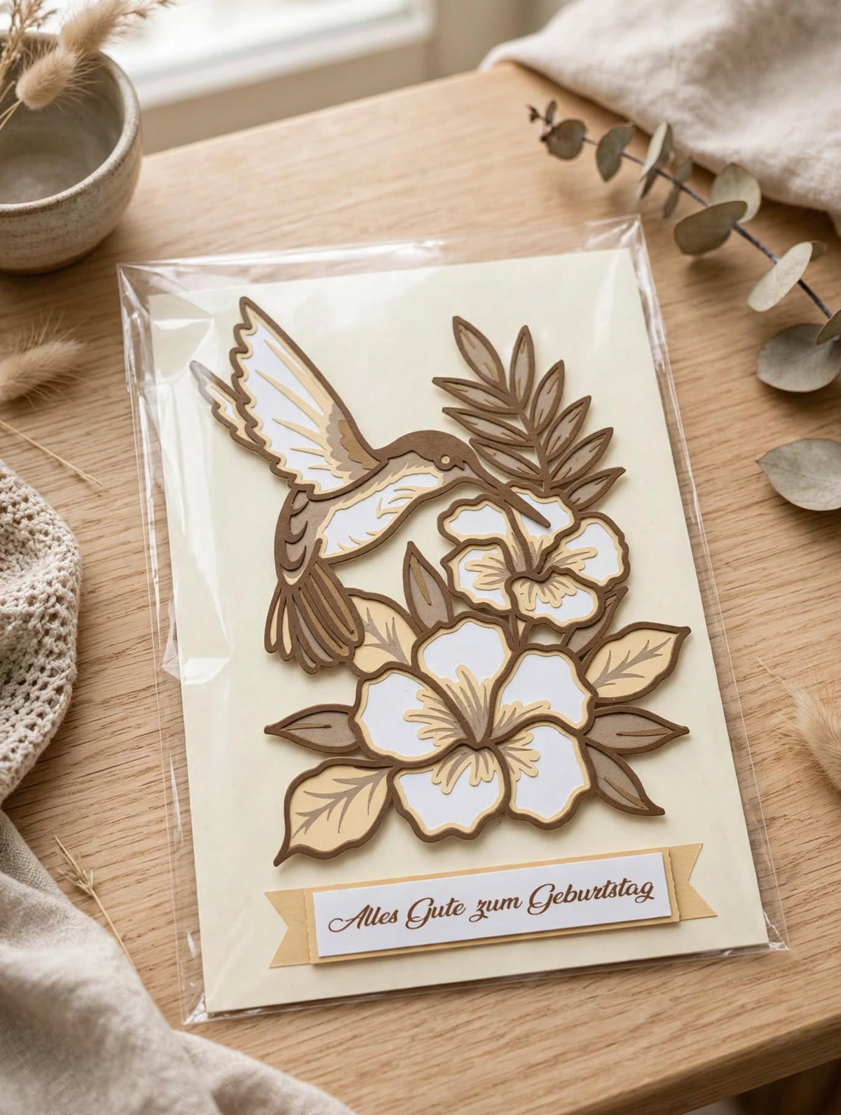 Geburtstagskarte Kolibri mit Blüten in Folie verpackt auf Holztisch - 3D Geburtstagskarte zum Verschenken
