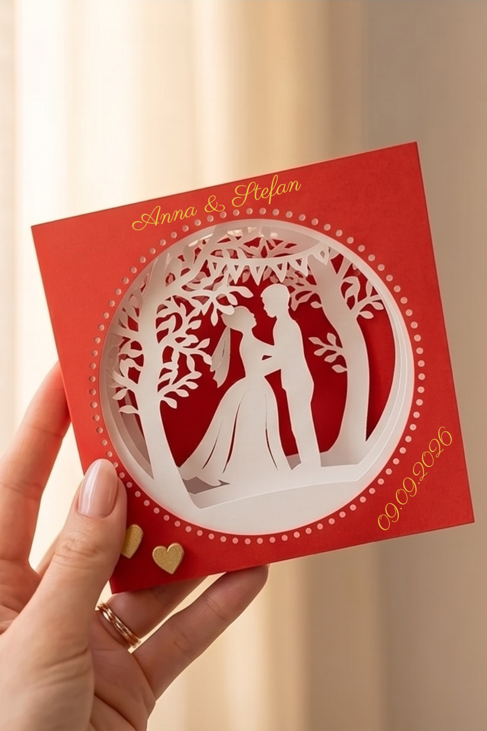 Hand hält bordeauxrote Tunnelkarte Hochzeit Brautpaar Motiv personalisierbar mit Namen und Datum in Gold wie auf Foto 2