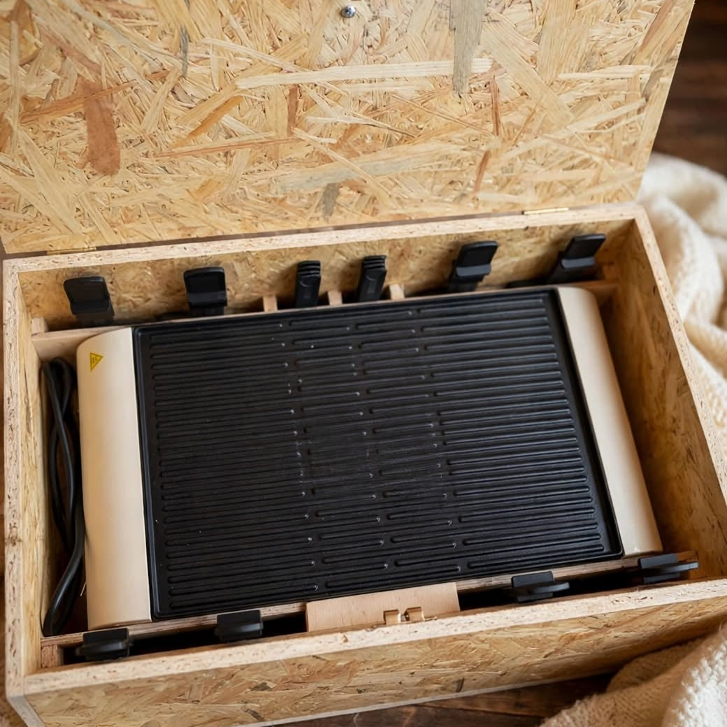 Raclette Ofen Kiste nach Mass offen mit beigem Raclette Grill und 6 Pfännchen Fächern aus OSB Holz handgemacht auf Wolldecke, handgemacht in Hämikon bei Hitzkirch