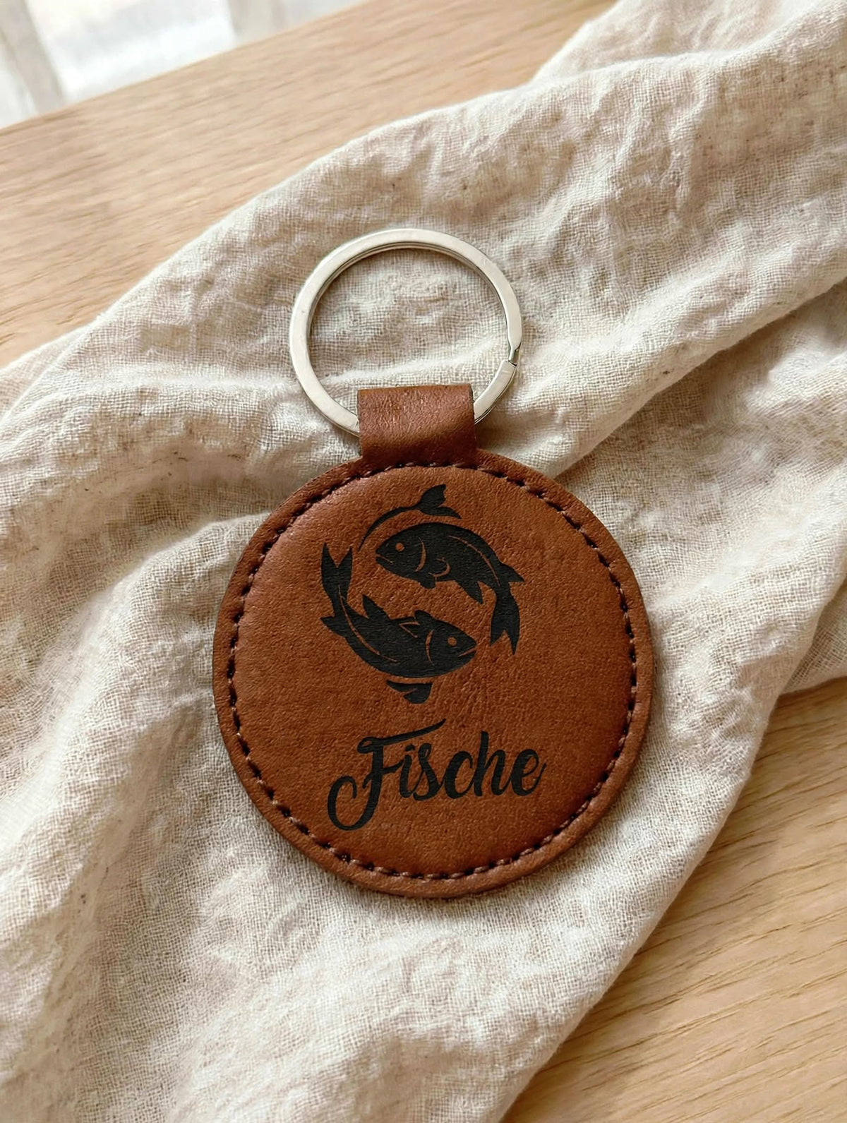 Schlüsselanhänger Sternzeichen Fische dunkelbraun cognac mit schwarzer Folie handgemacht mit Geheimfach auf Leinen