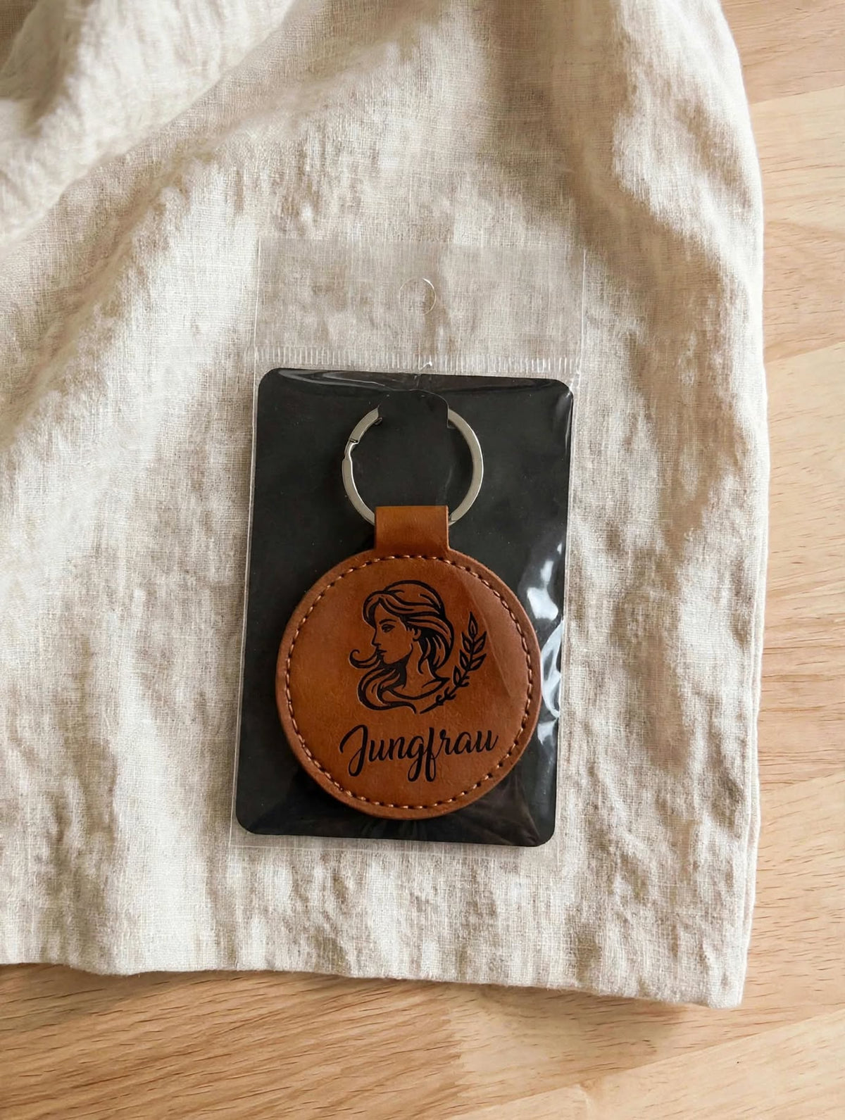 Schlüsselanhänger Sternzeichen Jungfrau dunkelbraun verpackt auf schwarzem Karton in Folie Geschenkverpackung