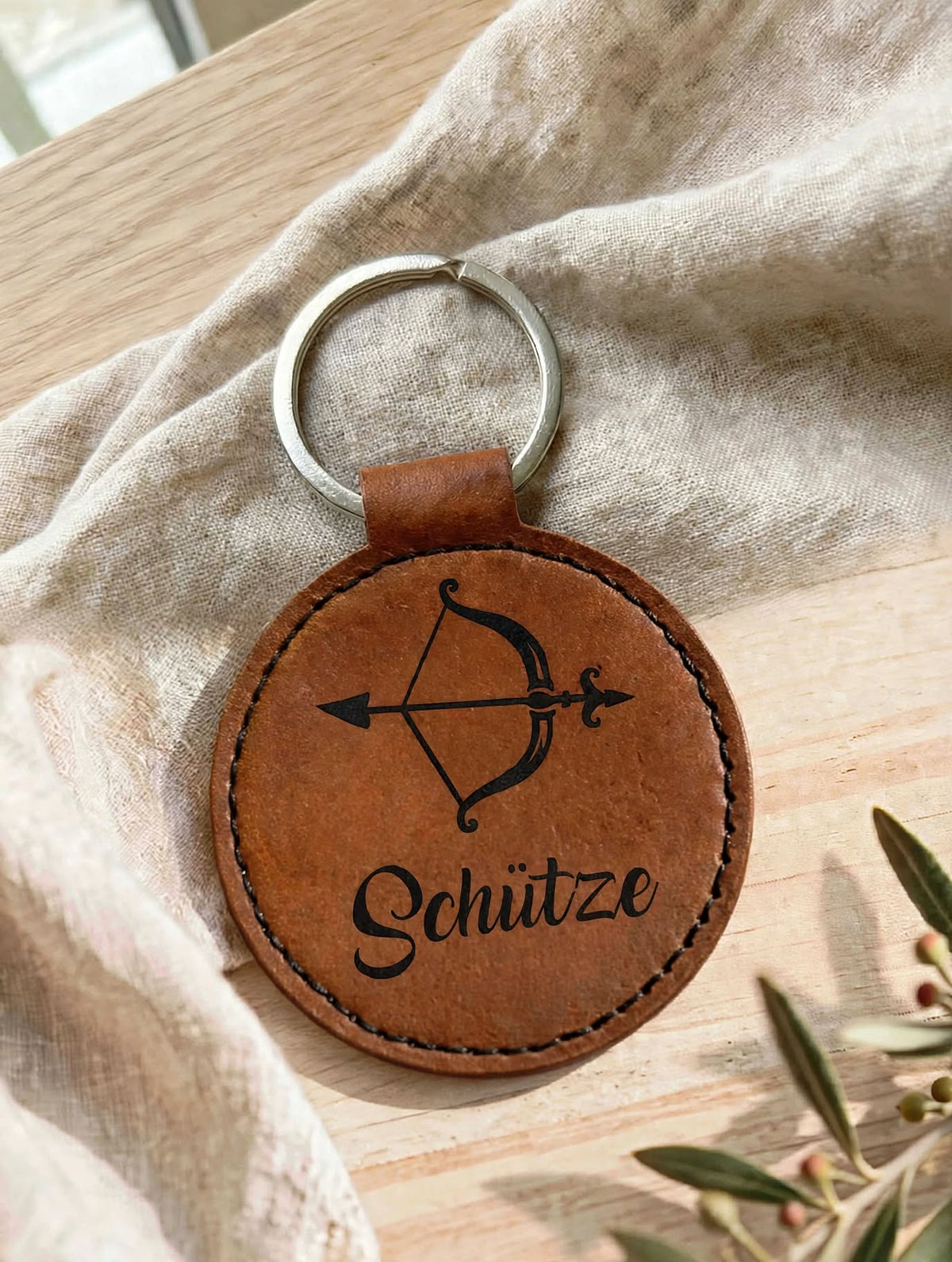 Schlüsselanhänger Sternzeichen Schütze in Braun Dunkel mit weissem Logo auf Leinentuch