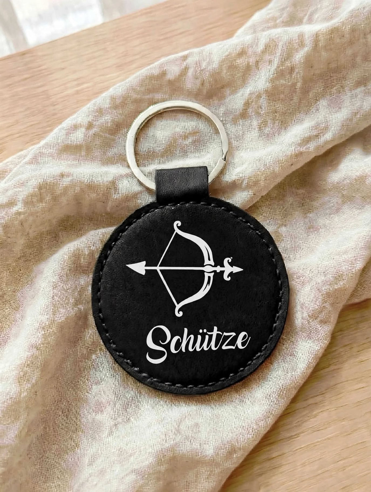 Schlüsselanhänger Sternzeichen Schütze in Schwarz mit weissem Bogen-Motiv und Schriftzug