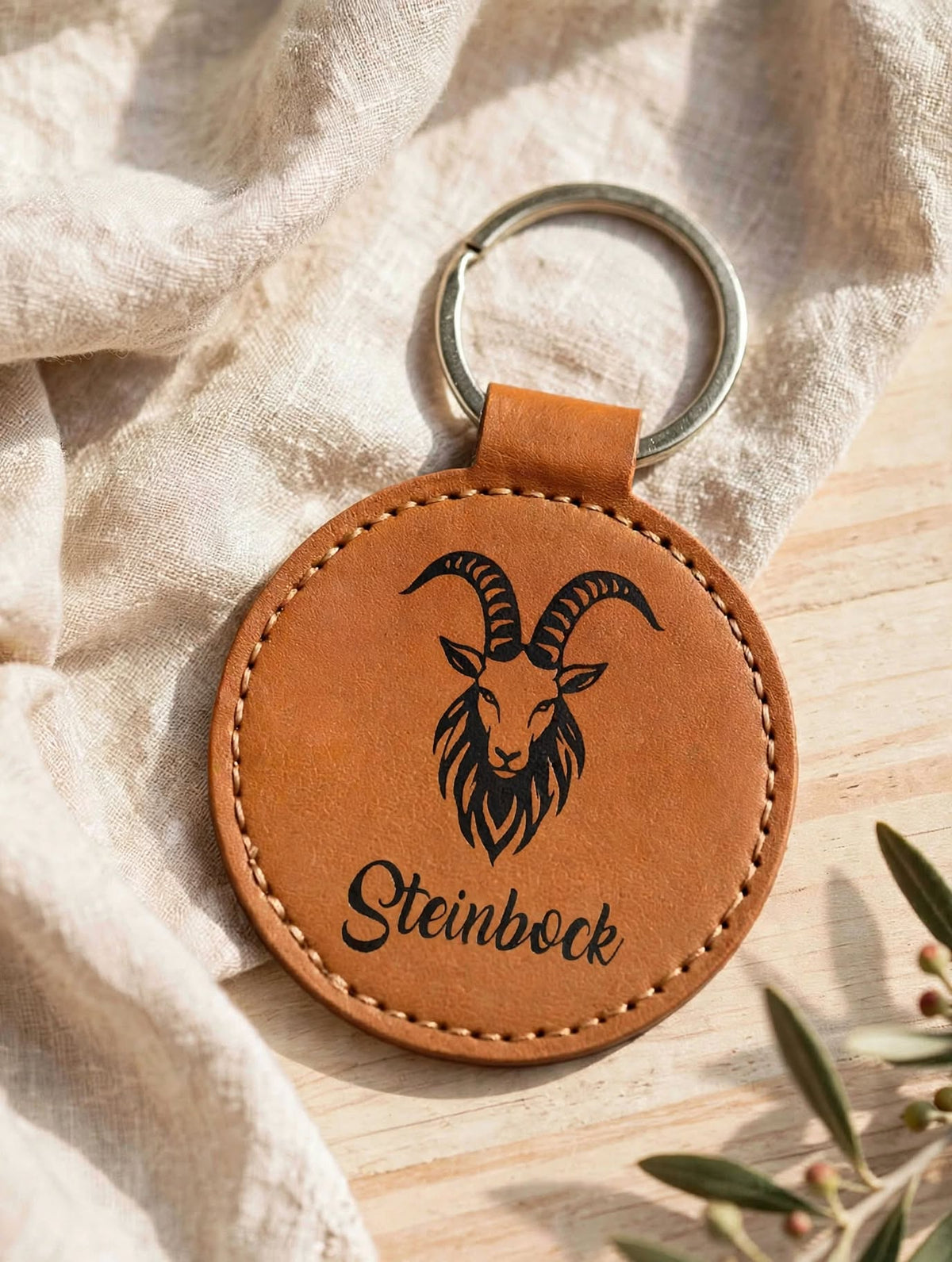 Schlüsselanhänger Sternzeichen Steinbock cognac mit schwarzer Folie auf Leinen mit Olivenzweig handgemacht mit Geheimfach