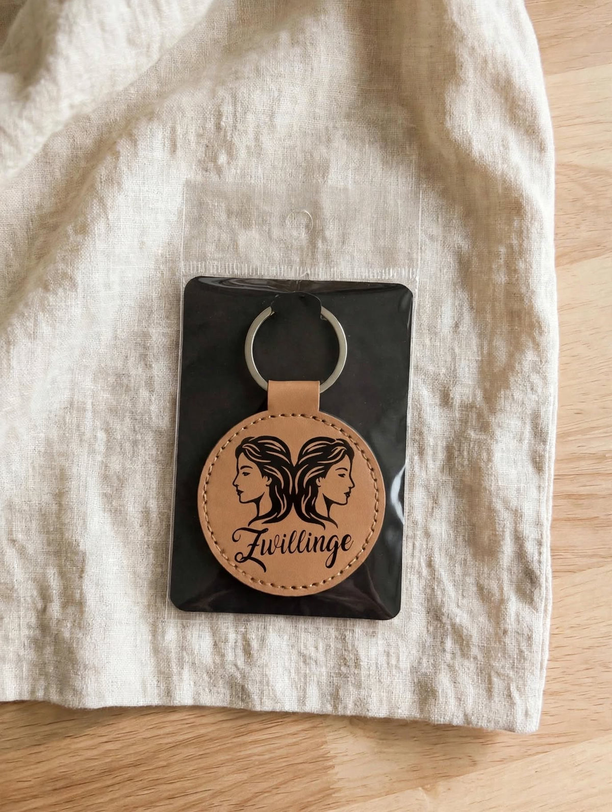 Schlüsselanhänger Sternzeichen Zwillinge hellbraun cognac mit schwarzer Folie eingepackt auf schwarzer Karte Geschenkverpackung handgemacht Hämikon Luzern